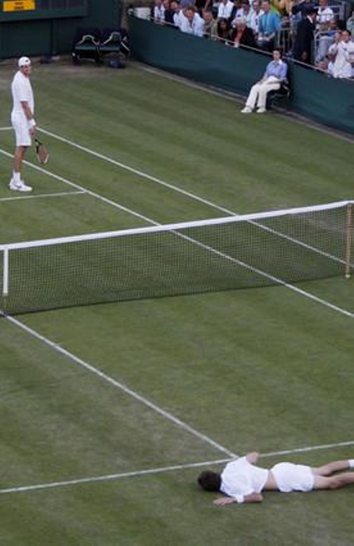 John Isner somriu a Nicolas Mahut després de l’últim punt del dia 23, que va deixar el partit amb 59-59.