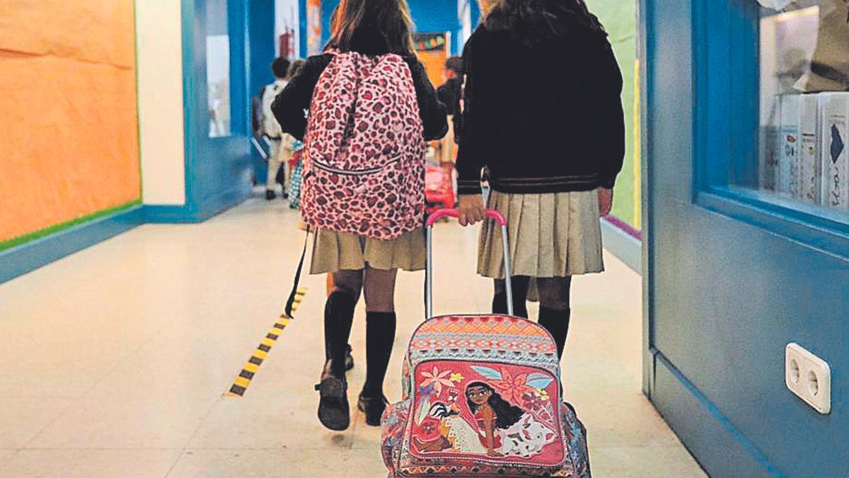 Dos alumnas caminan por los pasillos de un colegio.