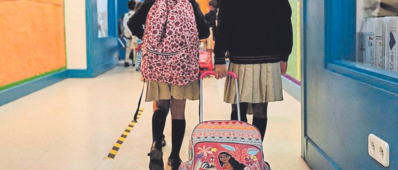 Dos alumnas caminan por los pasillos de un colegio.
