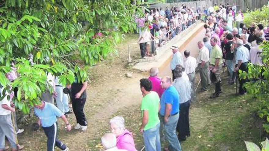 Un torneo de batiente en Puente Vega, Pravia, con la bolera repleta de público. /ocho