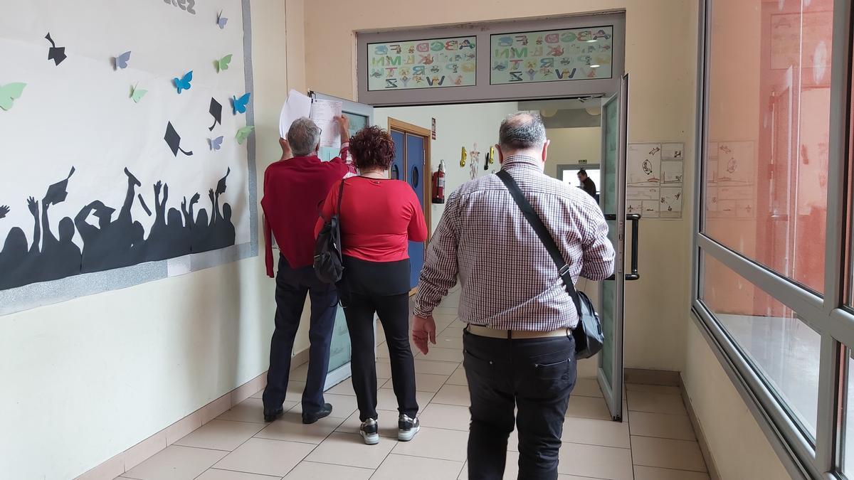 Votantes consultando el censo en el colegio Poeta Ángel González de La Corredoria.