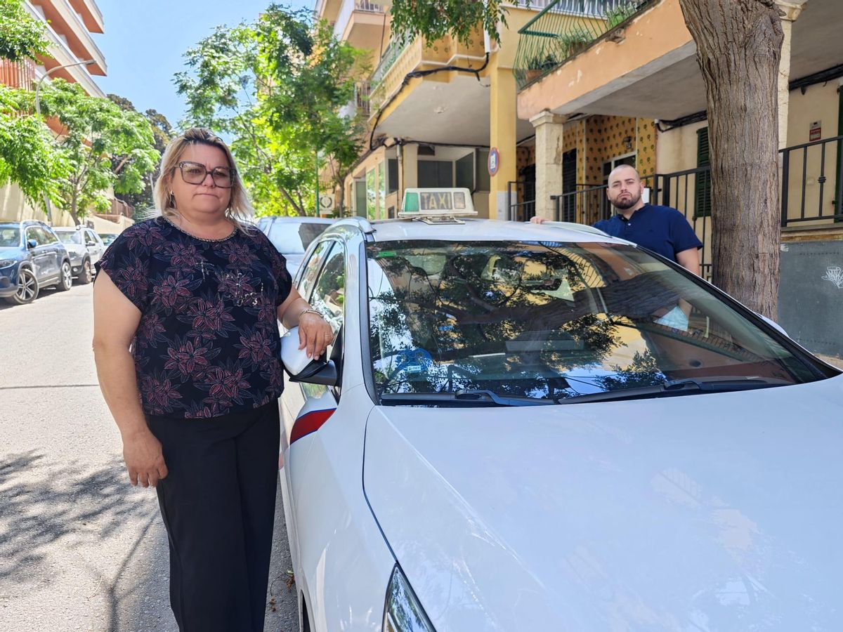 Canyellas y Peris posan junto a uno de sus taxis en las afueras de la sede de la entidad.