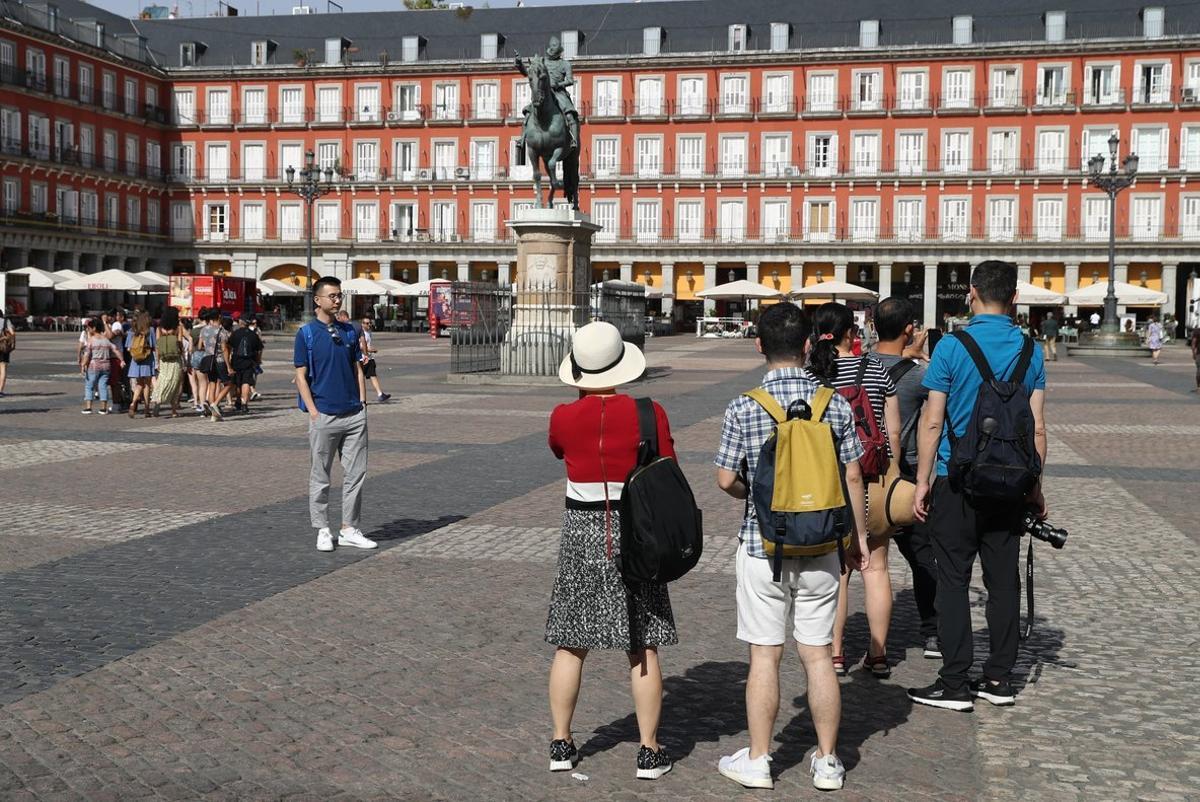 GRAF3170. MADRID, 12/07/2019.- Turistas en la Plaza Mayor de la capital de España. La caída de los precios de la energía ha contribuido a moderar la inflación en junio, que al situarse en el 0,4 % anual marca la tasa más baja desde septiembre de 2016, según ha confirmado este viernes el Instituto Nacional de Estadística (INE). Impulsó al alza el IPC la evolución del ocio y la cultura, cuyos precios bajaron un 0,4 %, ocho décimas menos que en mayo, por el encarecimiento de los paquetes turísticos en coincidencia con la campaña veraniega.- EFE/JJ Guillén