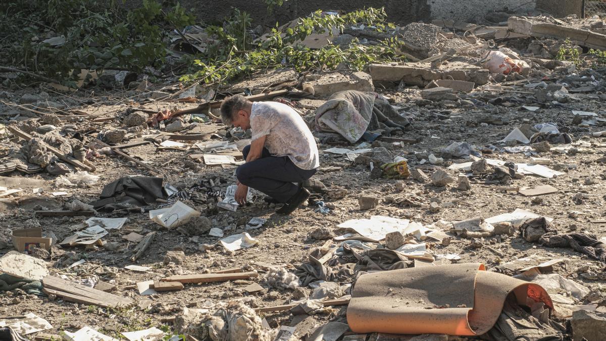 Un hombre buscando fotografías entre los escombros tras un bombardeo en una zona residencial de Mykolaiv, en el sur de Ucrania.