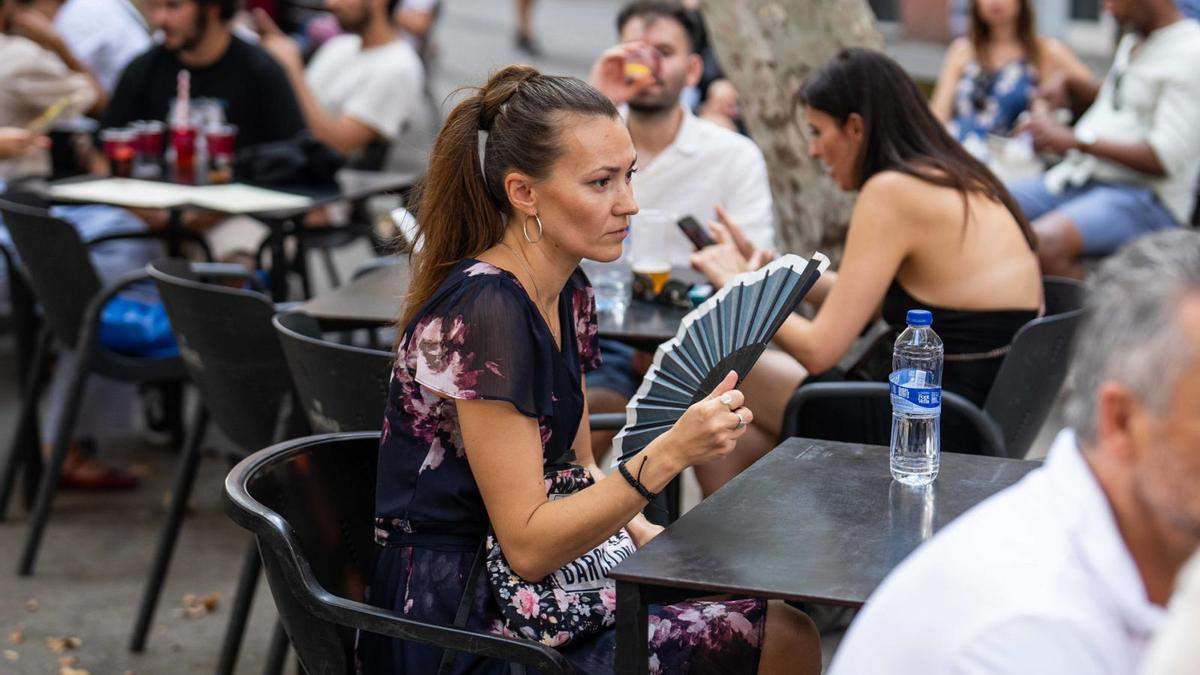 Una dona es venta en una terrassa d’un bar de Gràcia.  | ZOWY VOETEN
