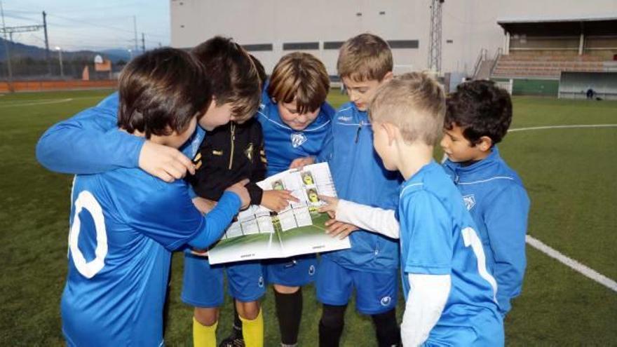 Los jóvenes jugadores se buscan en el álbum de cromos del Orpesa CF.