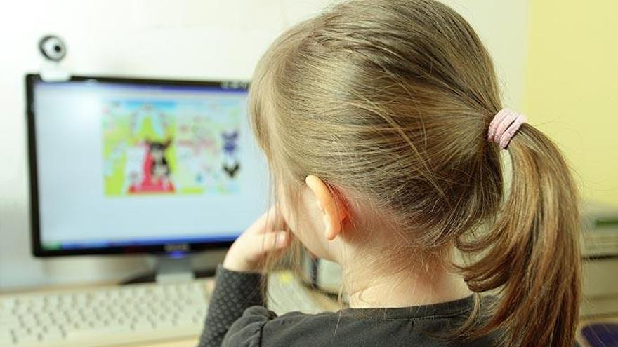 Una nena, davant d&#039;un ordinador amb una webcam