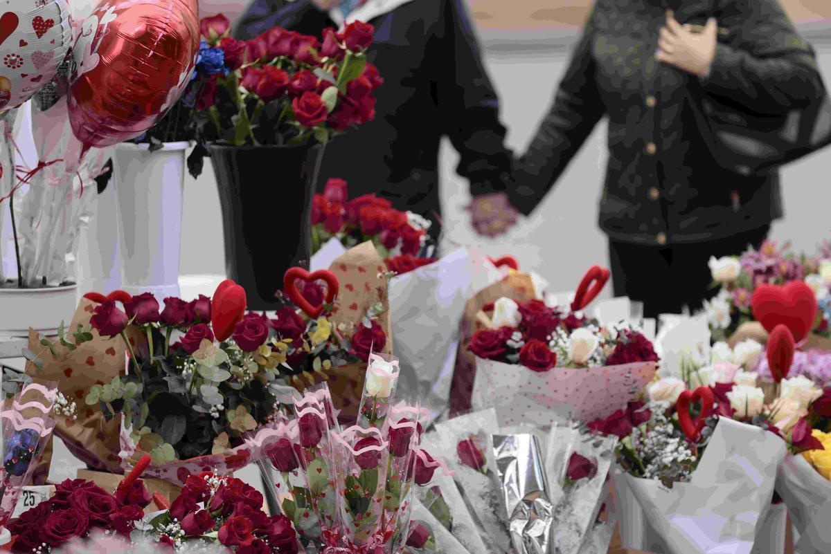 Una pareja contempla una vitrina con productos en torno al día de San Valentín.