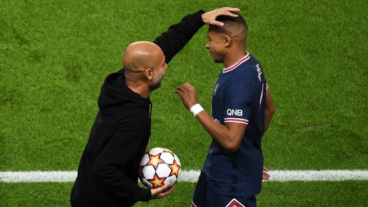 Pep Guardiola (L), hace un gesto con el delantero francés del Paris Saint-Germain, Kylian Mbappé.