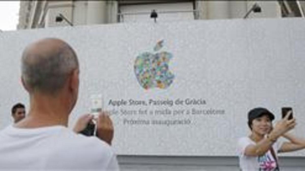 Unos turistas se fotografían ante la nueva tienda de Apple del paseo de Gràcia