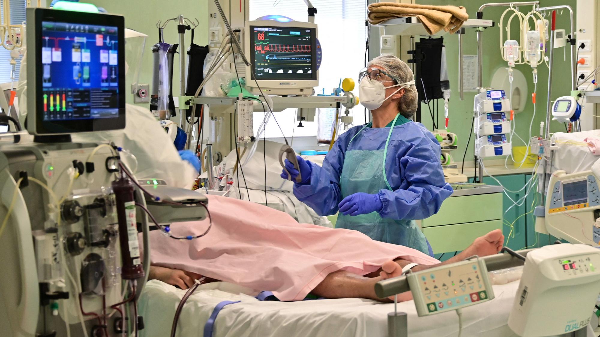 A member of the medical staff wearing personal protective equipment (PPE) works by a patient in the Covid-19 intensive care unit (ICU) of the Bolognini hospital in Seriate, Bergamo, on March 12, 2021, amid the Covid-19 (novel coronavirus) pandemic. - At the Seriate hospital, near Bergamo, the intensive care unit is once again full, its eight beds occupied by coronavirus patients, even if the numbers are not as high as last year. &quot;Covid is more aggressive now, with many cases of the new English variant,&quot; said the director of the unit, noting the relatively young age of his patients. (Photo by Miguel MEDINA / AFP) Seriate