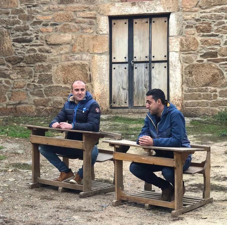 Martín del Río y el alcalde-presidente del Ayuntamiento de Fonfría, Sergio López, sentados en dos antiguos pupitres que formarán parte del museo.