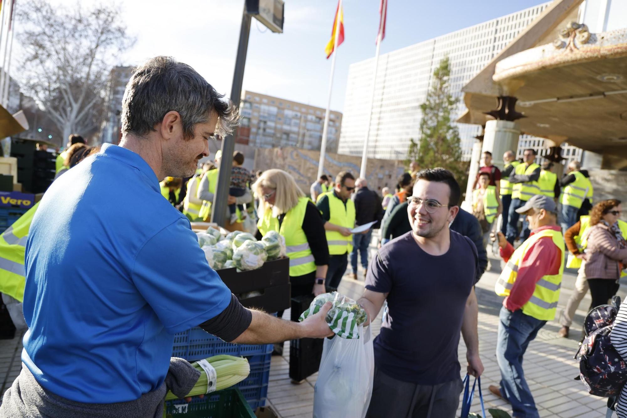 Las imágenes del plante de los agricultores frente a la Asamblea, donde han repartido frutas y hortalizas