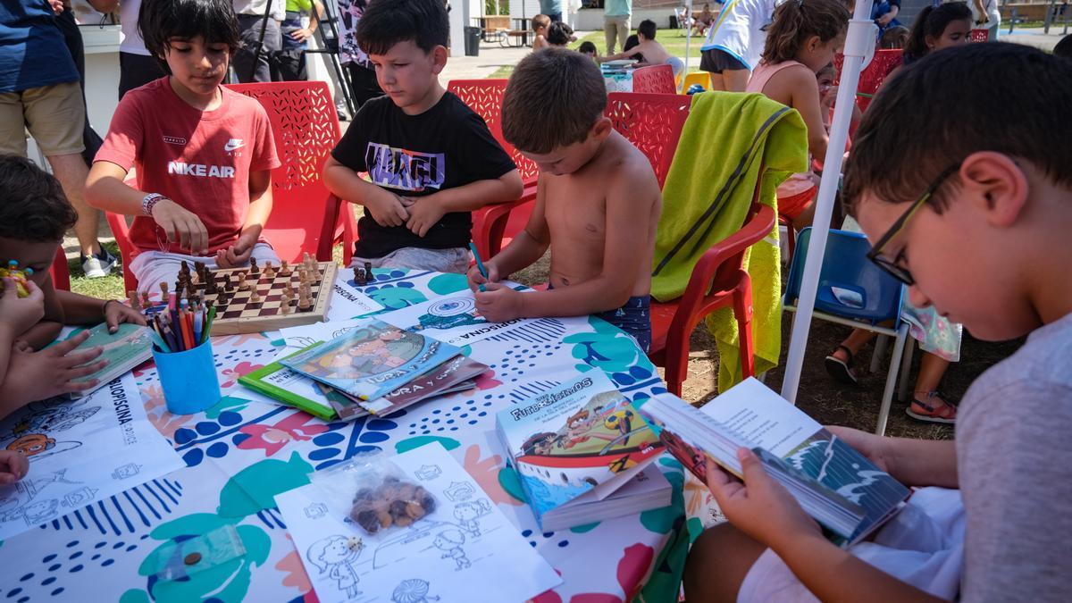 Algunos de los niños disfrutando del servicio con libros, ajedrez y dibujando.