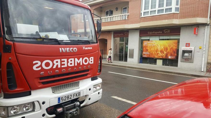 Imagen de la sucursal y de un vehículo de los bomberos esta mañana.