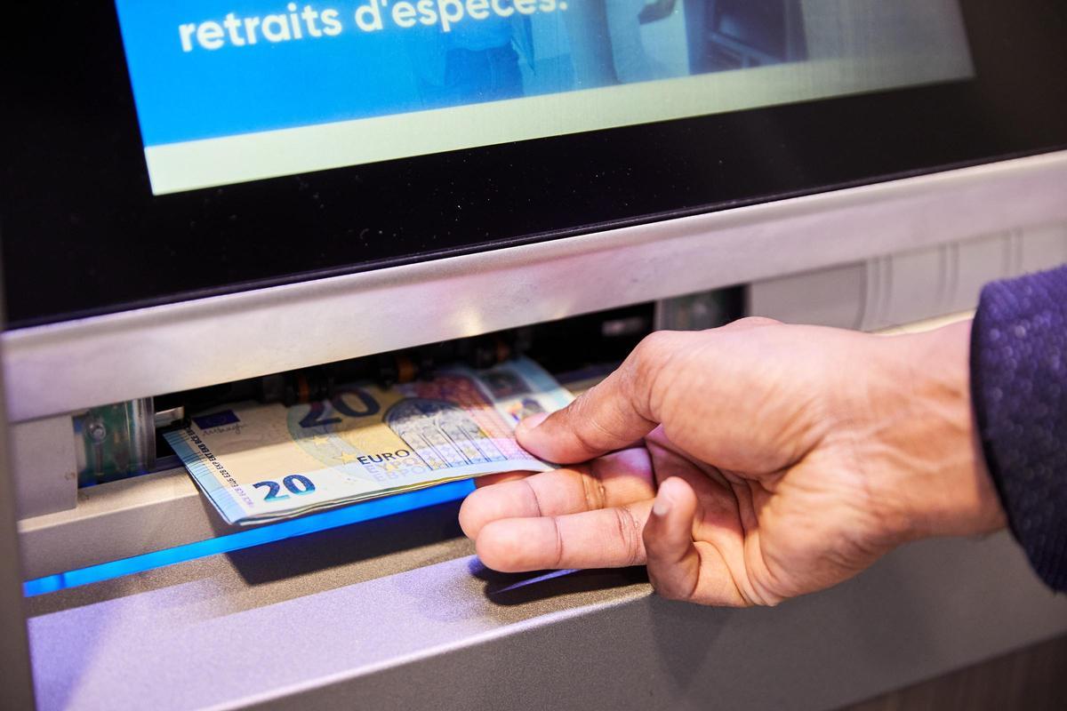 Una persona saca dinero de un cajero automático