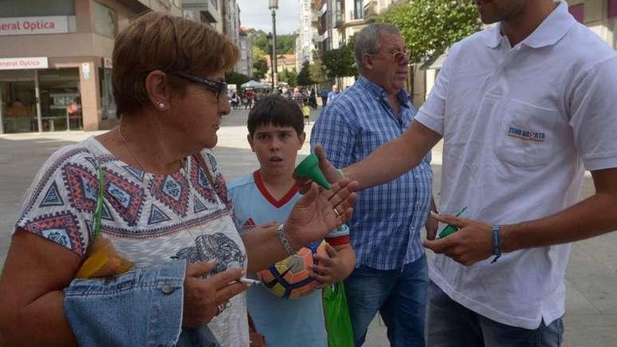Reparto de cucuruchos de plástico en Praza de Galicia. // Noé Parga