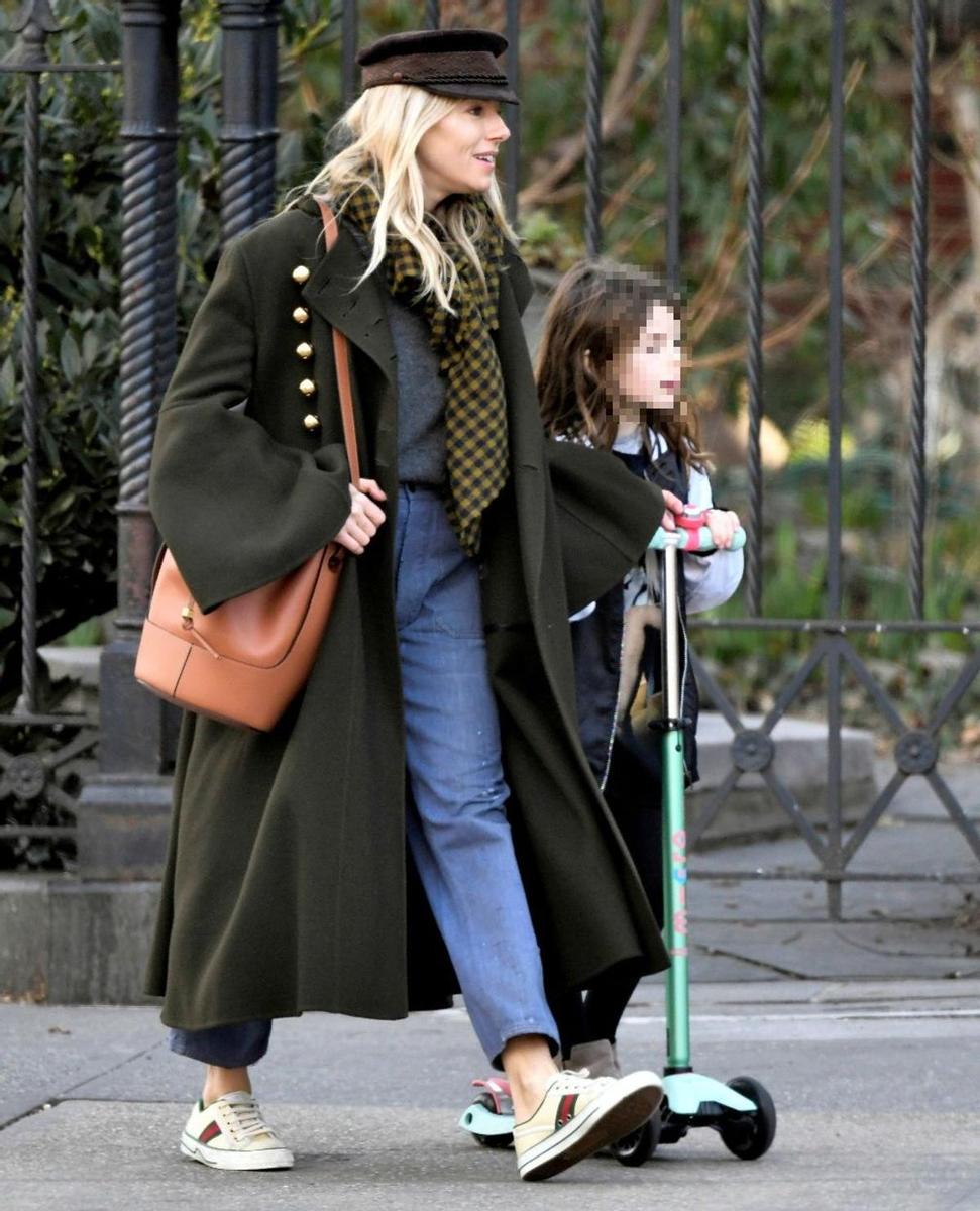 Sienna Miller con abrigo largo verde y vaqueros