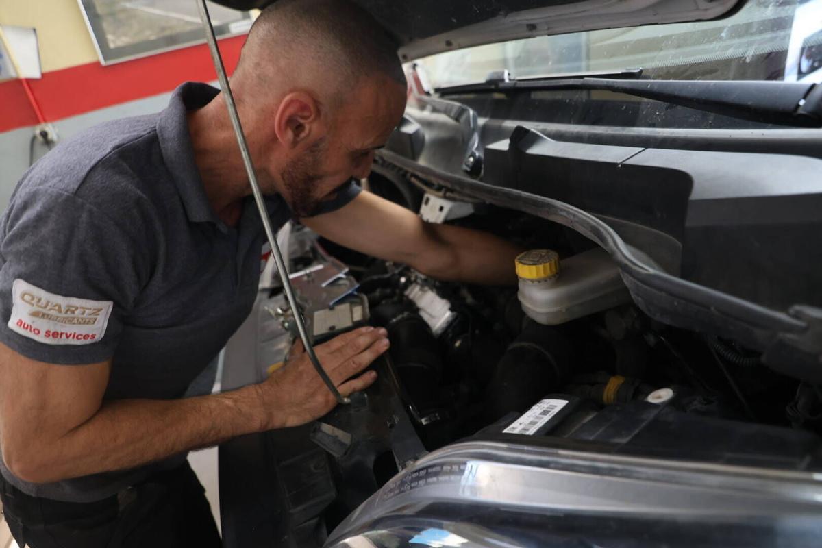 Un mecánico trabaja en un coche en Talleres Cortijo.
