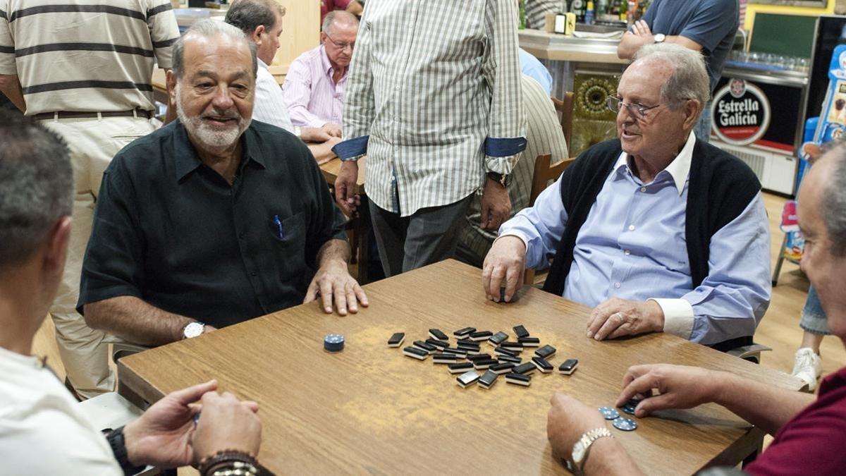 Los empresarios Carlos Slim (izquierda) y Olegario Vázquez, este martes, jugando al dominó en un bar de Avión (Ourense).