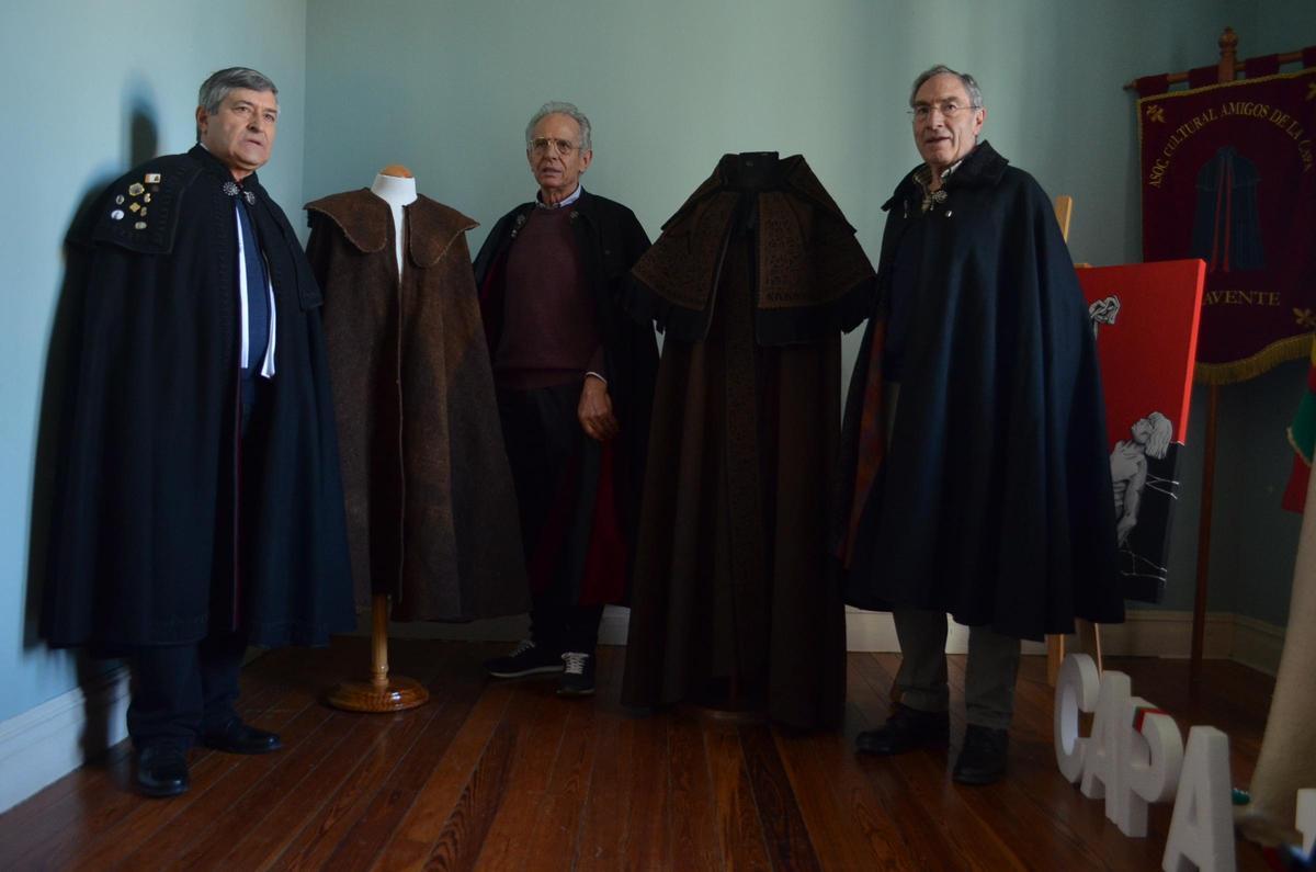 Amigos de la Capa con la pieza más antigua de la exposición (a la izquierda) y la cedida por Miranda do Douro (derecha).
