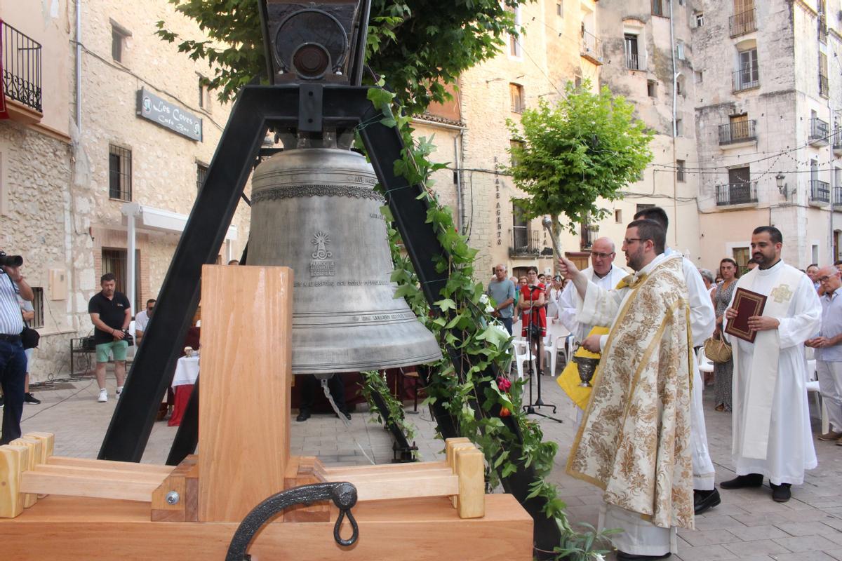 La nueva campana, mientras es bendecida por el párroco.