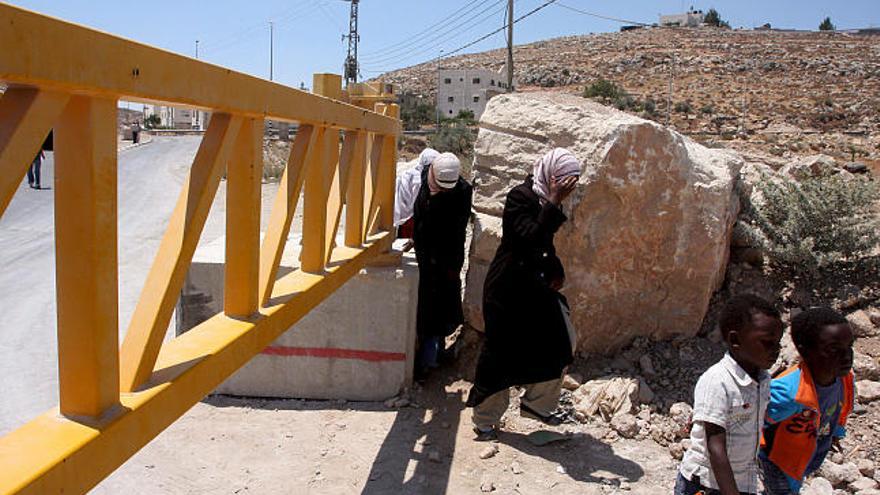 Varios palestinos caminan cerca de la frontera israelí tras ser cerrada por los soldados israelíes en la ciudad cisjordana de Hebrón.