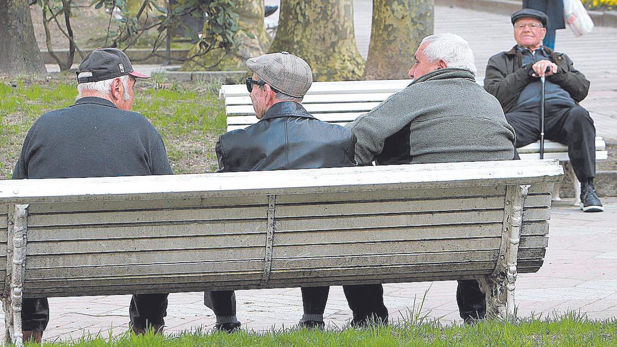 Un grupo de pensionistas charla en un parque.