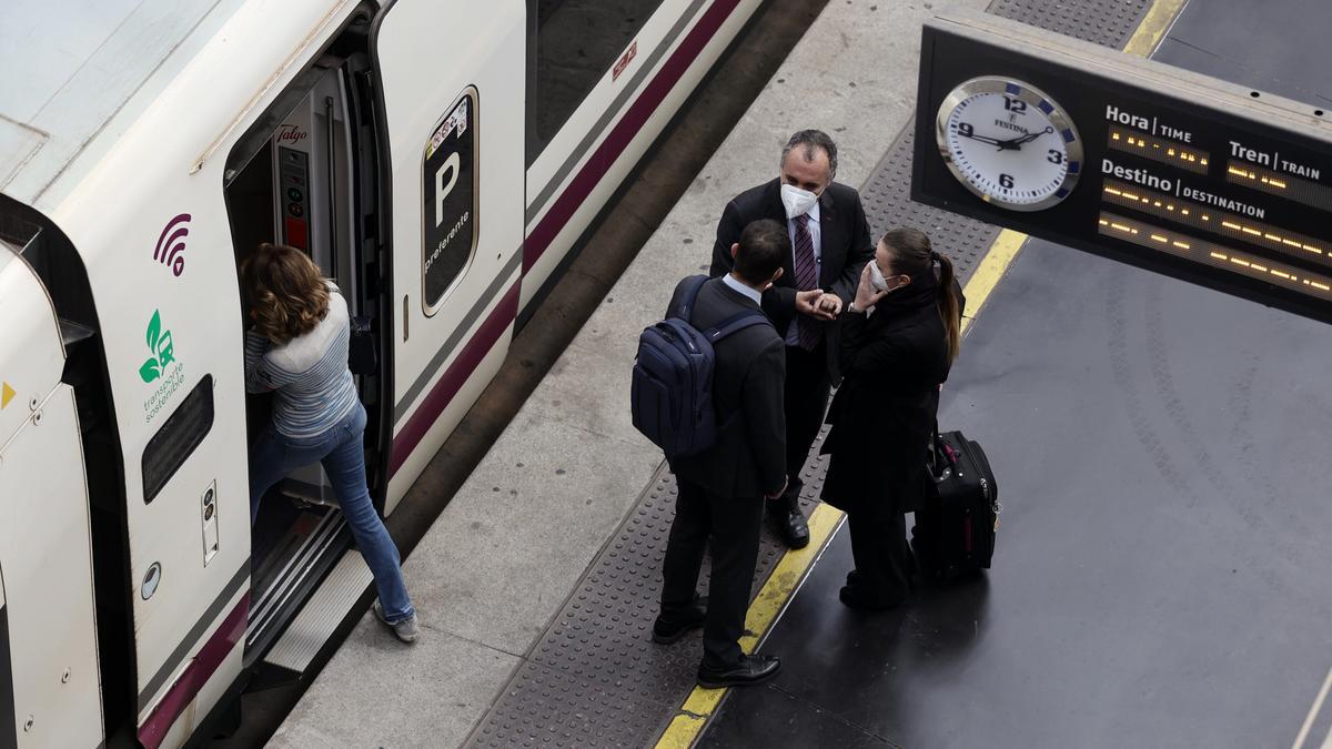 Varias personas, con maletas, en un andén de la estación de Atocha.