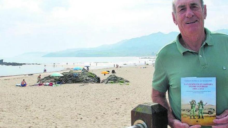 Carlos Blond, en la playa de La Isla, con su libro.