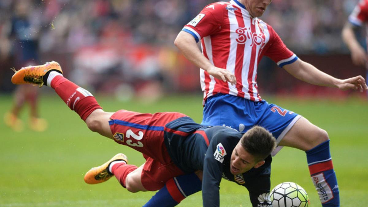 El jugador del Atlético VIetto cae ante Mere, del Sporting, en El Molinón