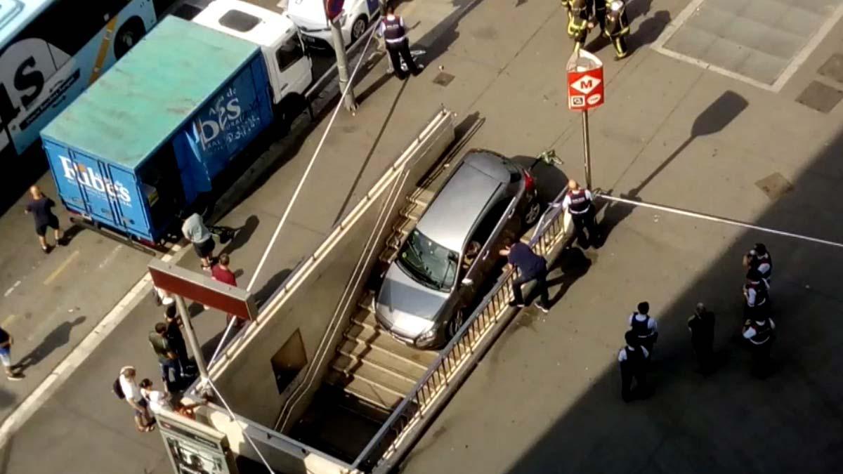 Una conductora encasta su coche en una boca del metro de la plaza Espanya de Barcelona.