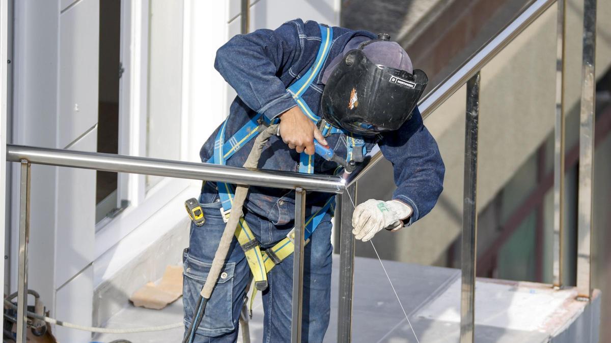 Un soldador durante el montaje de una barandilla en un edificio en construcción.