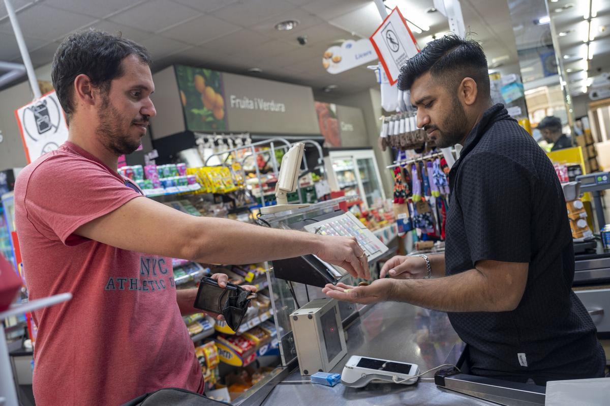 Un hombre abona el importe de su compra en un supermercado de Barcelona.