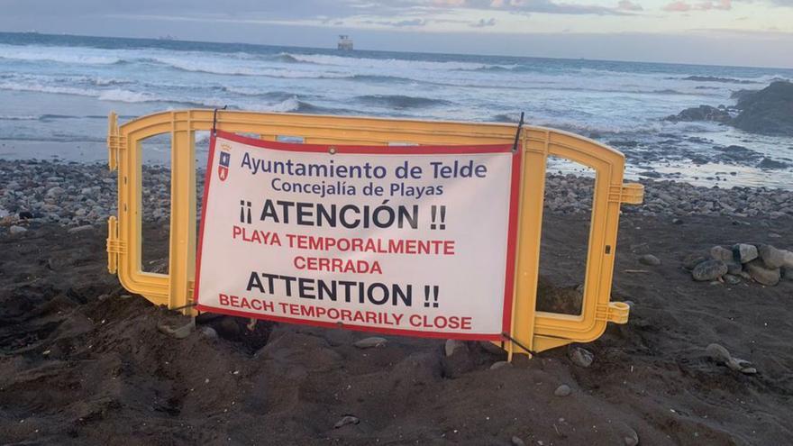 Una valla que informa sobre el cierre temporal de la playa. | | LP/DLP