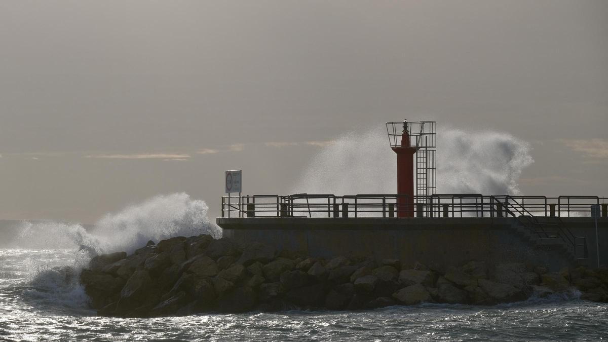 El oleaje sobrepasa uno de los dos faros de la bocana del Club Náutico Portitxol