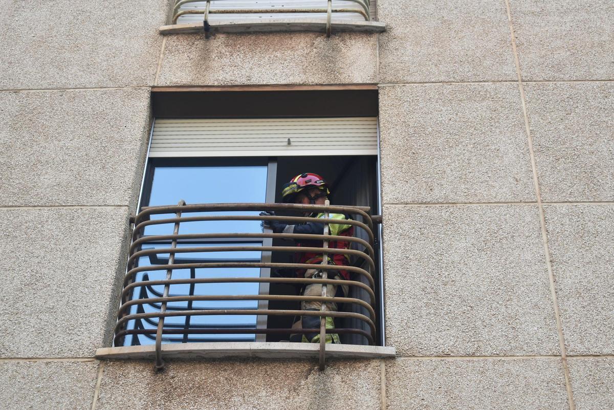 Uno de los bomberos en una ventana del piso.