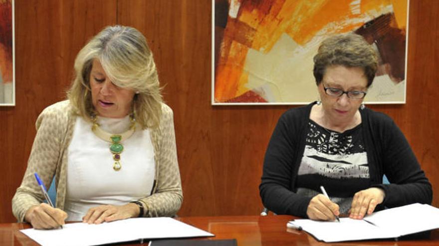 Ángeles Muñoz y Carmen Martínez Aguayo firmando el acuerdo.