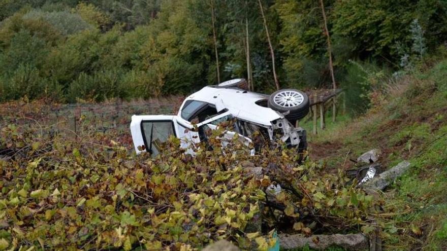 El vehículo volcado tras caer por un terraplén en Marín. // S. Álvarez