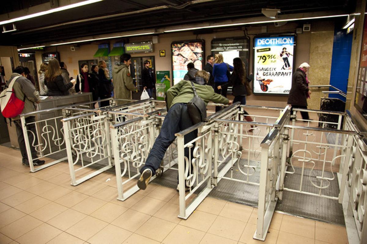 Un joven se cuela en el metro en la estación de la L-1 de Urquinaona, ayer.