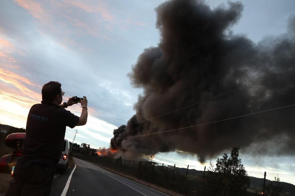 Labores de extinción del incendio de un desguace en Gijón