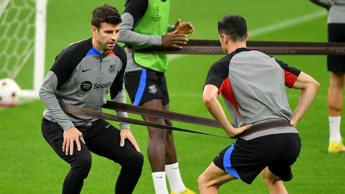 Piqué y Lewandowski, en el entrenamiento previo al Inter-Barça.