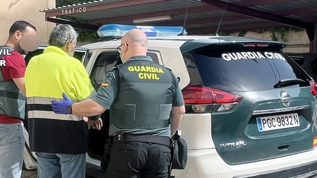 Agentes de la Guardia Civil meten en el coche al presunto autor de los hechos.