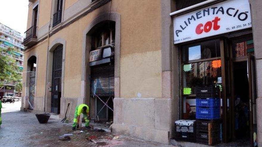 Treballadors de la neteja municipal retiren restes d&#039;objectes al davant de la fleca on va tenir lloc l&#039;explosió