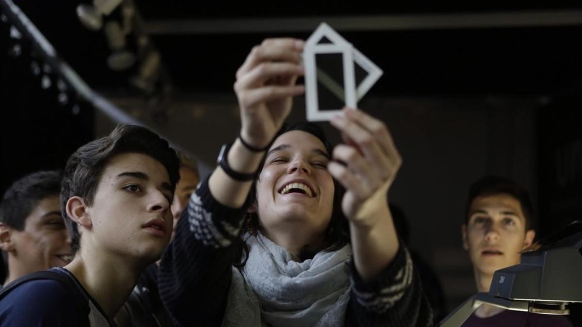 Unos estudiantes escuchan atentos una explicación práctica en el Saló de l'Ensenyament.