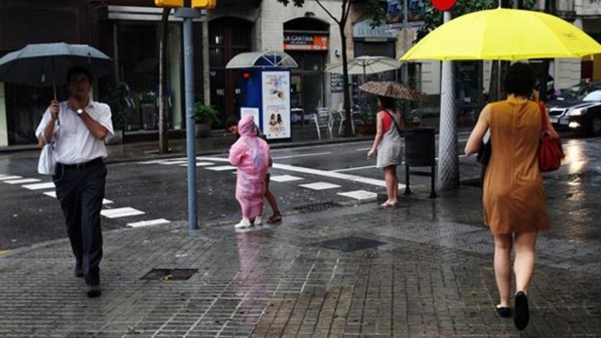 La lluvia ha obligado a los barceloneses a sacar los paraguas.