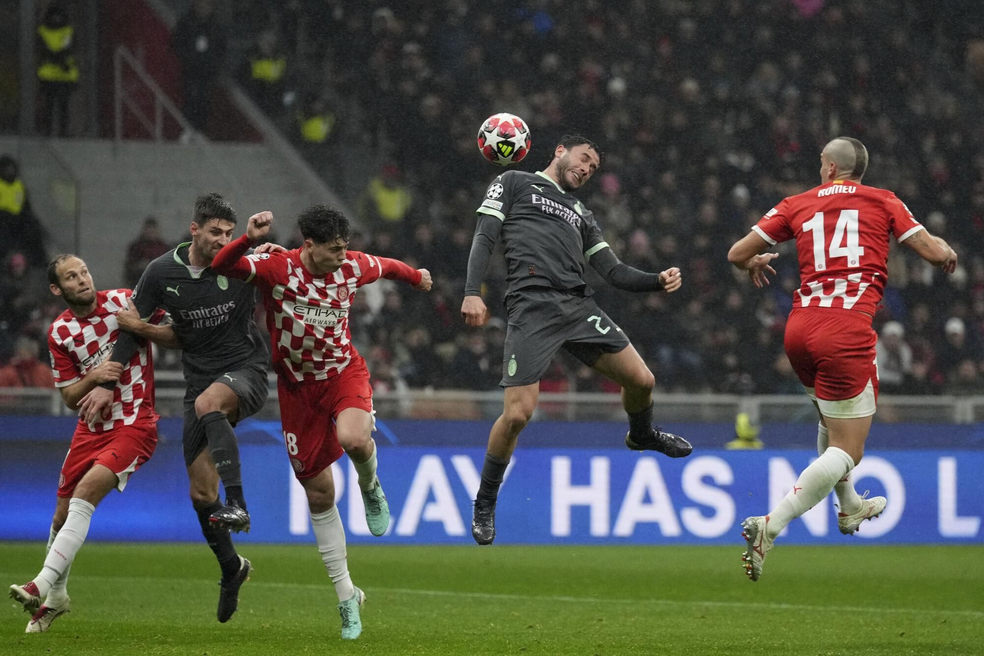 AC Milan's Davide Calabria, centre right, heads clear during the Champions League opening phase soccer match between AC Milan and Girona at the San Siro stadium in Milan, Italy, Wednesday, Jan. 22, 2025. (AP Photo/Antonio Calanni)
