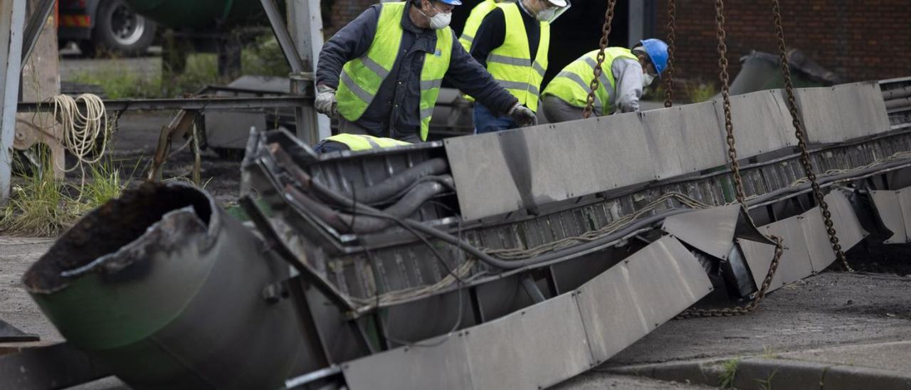 Un grupo de trabajadores, junto a una tubería cortada en una anterior obra de desmantelamiento parcial de las instalaciones de baterías de coque. | Ricardo Solís