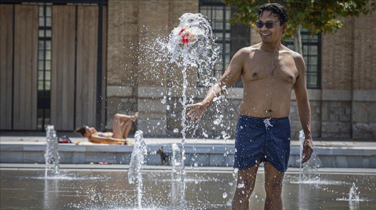 Un hombre se refresca en la fuente del Parque Central de Valencia.