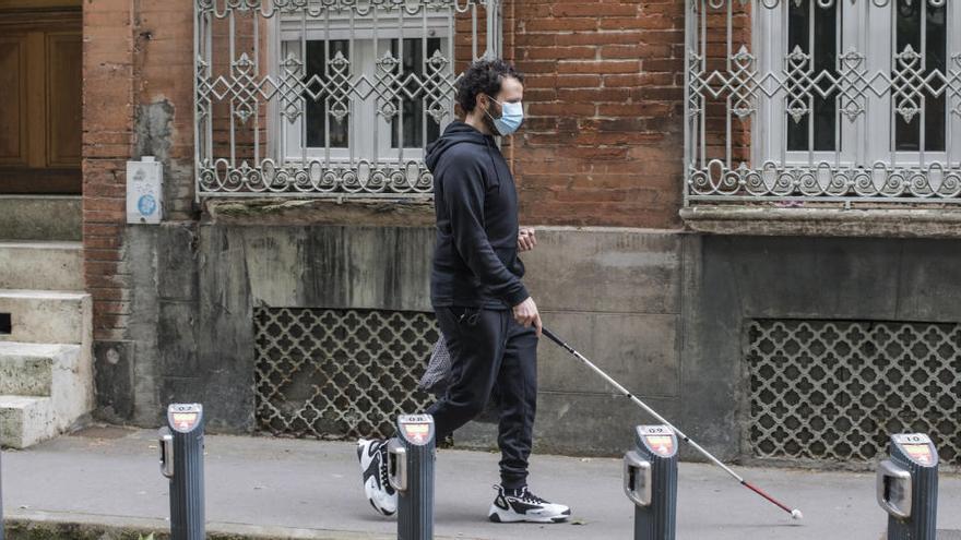 Una persona ciega pasea por Toulouse (Francia)